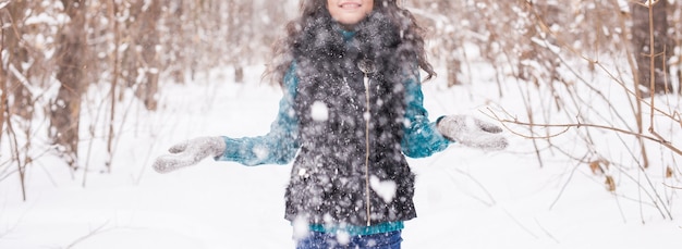 Saison-, Freizeit- und Menschenkonzept - Nahaufnahme der Frau ist glücklich und wirft Schnee in die Winternatur