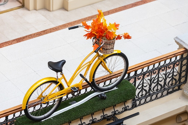 Saisonale Dekoration eines teuren Schaufensters. Retro-Fahrrad in einem Korb mit einem Strauß Herbstblätter