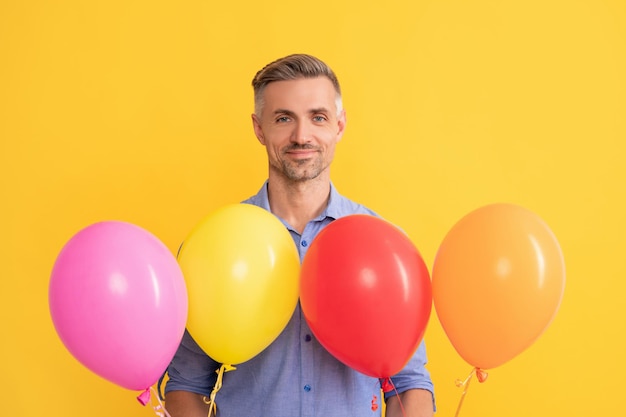 Saisonale Verkäufe. Mann mit Partyballons. Geschenk und Geschenke kaufen. reifer einkaufender typ mit kauf