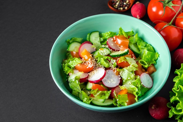 Saisonaler Gemüsesalat aus Bio-Bauernhof-Produkten auf grauem Hintergrund Mischung aus Tomaten-Gurken