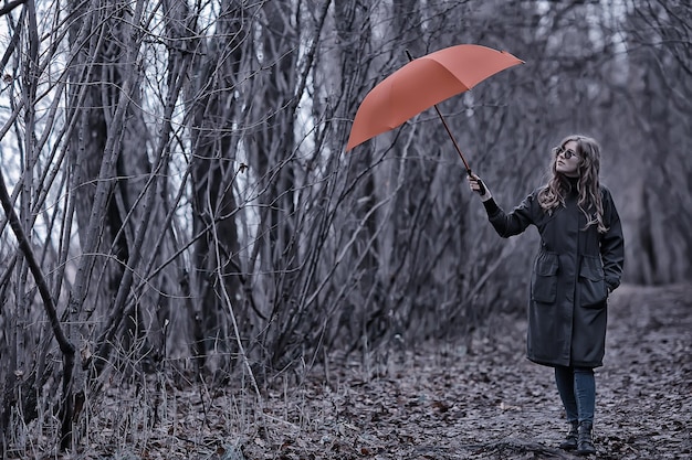 saisonales Herbstporträt, trauriges Mädchen mit Regenschirm, saisonale Virusimmunität im November bei einem Spaziergang