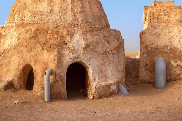 SAKHARA, Tunísia - 17 de maio de 2021: O cenário abandonado do planeta Tatooine para as filmagens de Star Wars no Deserto do Saara com dunas de areia ao fundo