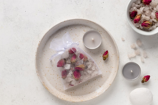Sal de baño artesanal con rosas y hierbas en bolsa de rejilla. Bolsa de té de baño. Productos de aromaterapia de bricolaje. Fondo blanco