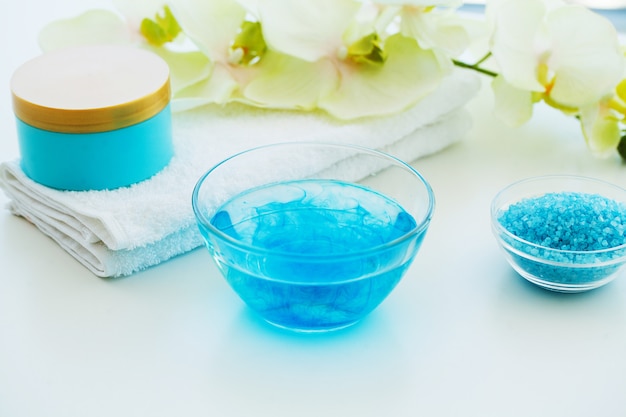 Sal de baño azul, crema corporal y conchas para spa