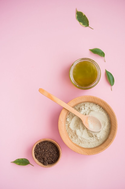 Sal de baño cosmética, goma de uva para la cara, exfoliante de café para el cuerpo sobre una superficie rosa