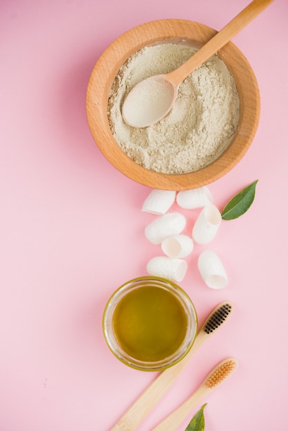 Sal de baño cosmética, goma de uva para la cara, exfoliante de café para el cuerpo sobre una superficie rosa