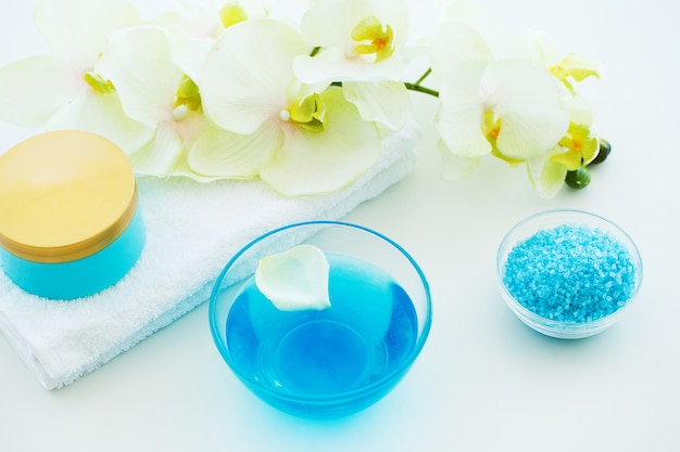 Sal de banho azul, creme corporal e conchas para spa