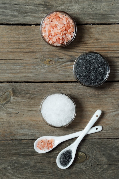 Sal de diferentes tipos - mar, preto, himalaia em salinas de vidro em um fundo cinza de madeira