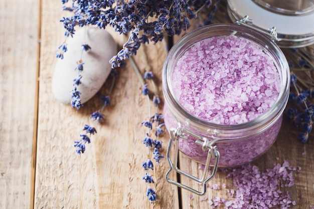 Sal de lavanda com produtos naturais de spa e decoração para banho em fundo de madeira