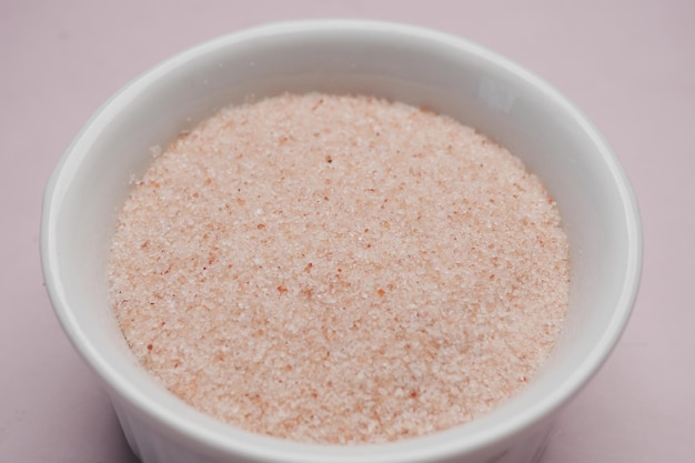 Sal do Himalaia rosa seco inteiro cru em um recipiente em branco