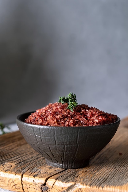 Sal infundida con vino tinto casero en un bol negro Condimento para aromatizar y sazonar la comida