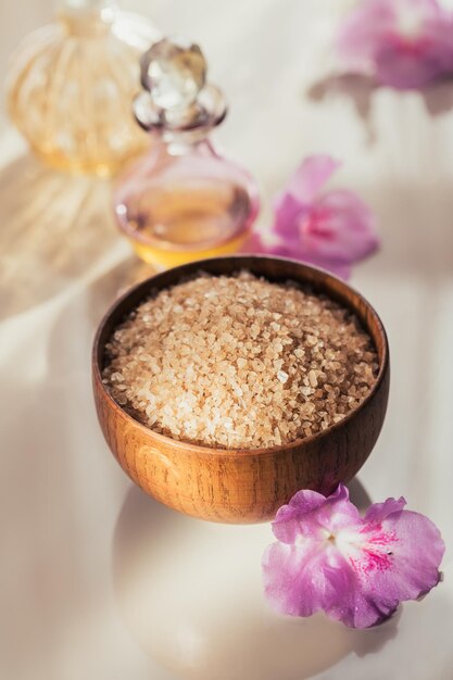 Sal marinho sabonete artesanal natural óleo cosmético natural e toalhas coloridas com flores de azaleia em fundo de madeira rústica