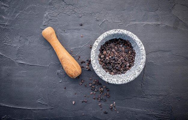 Foto sal negra del himalaya sobre fondo de hormigón oscuro sal del himalaya comúnmente utilizada en la cocina y para productos de baño como sales de baño