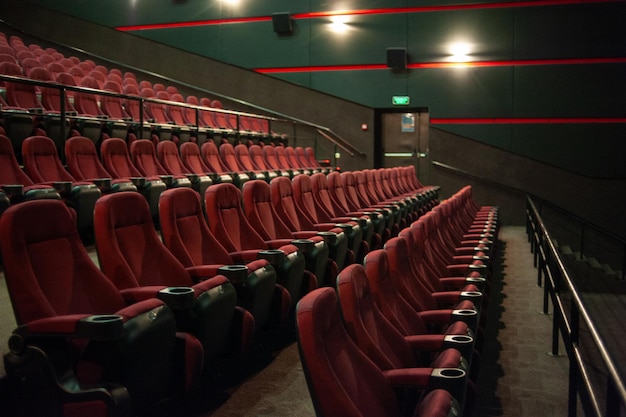 Una sala de cine con asientos rojos y un letrero que dice 'salir'