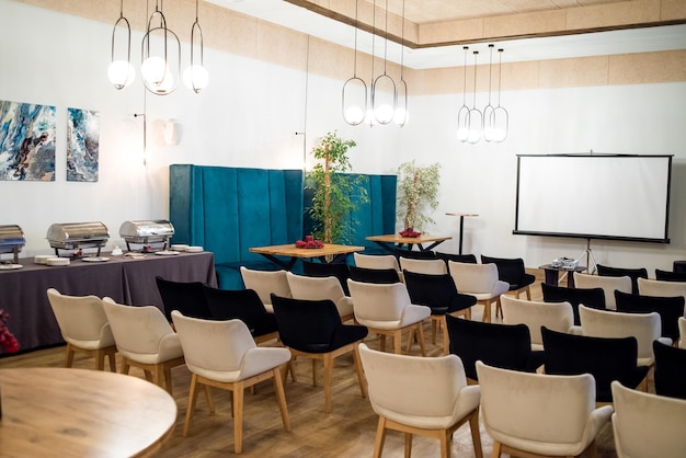 Sala de conferencias de reuniones con pantalla de maqueta vacía en blanco para publicidad