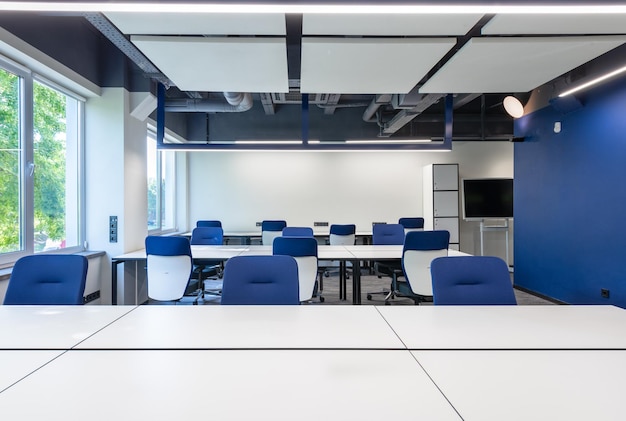 Foto una sala de conferencias con una silla azul y un piso blanco con una silla azul en el medio
