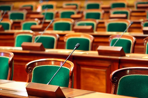 Sala de congresos vintage vacía con asientos y micrófonos.