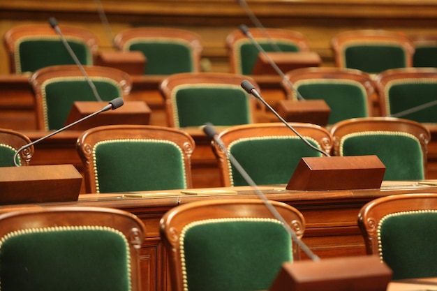 Sala de congresos vintage vacía con asientos y micrófonos.