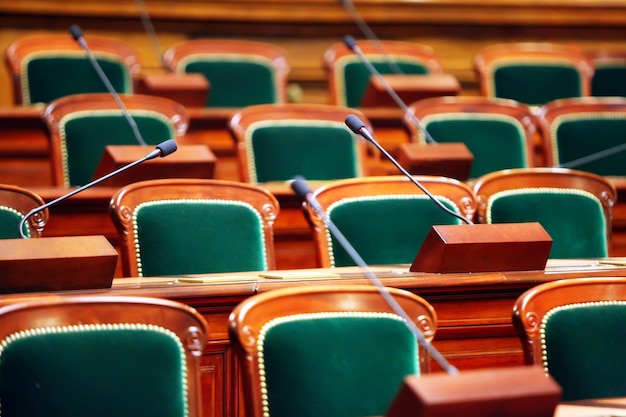 Sala de congresos vintage vacía con asientos y micrófonos.