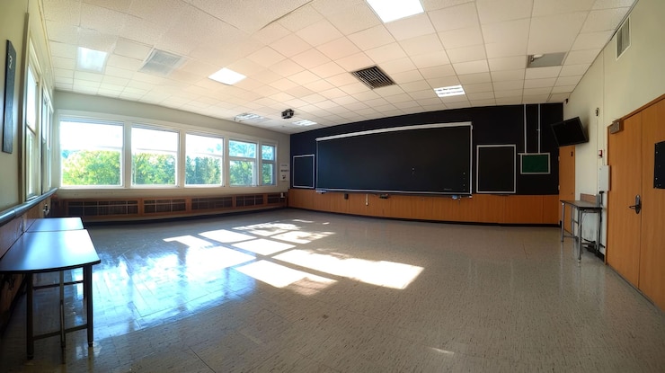Foto sala de aula vazia com janelas, quadro preto e portas de madeira
