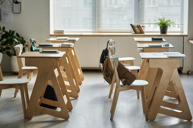 Sala de aula vazia com mesas para alunos