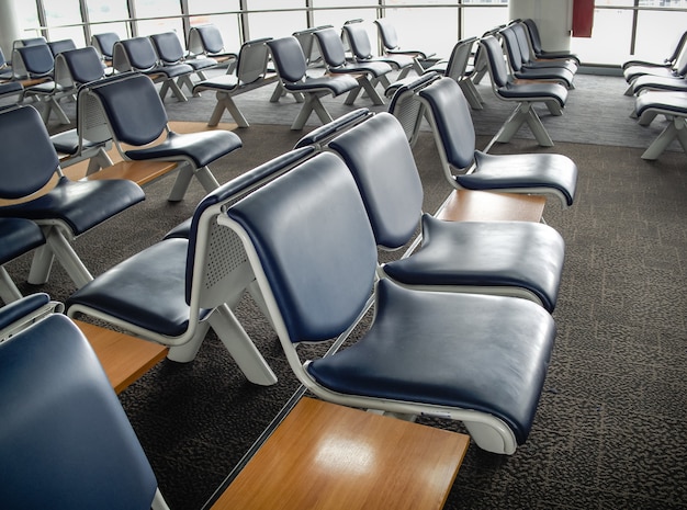 Sala de embarque no terminal do aeroporto com assentos vazios dos passageiros.