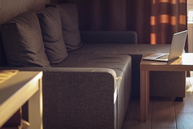 Sala de estar à luz do pôr-do-sol Sofá e mesa vazios Local de trabalho distante Fim do dia de trabalho