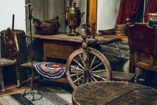 Sala de estar com móveis antigos e utensílios desatualizados Vida rural dos camponeses russos Roda de fiar e samovar Local da velha cabana Vista interna