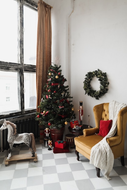 Foto sala de estar decorada para o interior de natal de ano novo com uma árvore de abeto com guirlandas e enfeites