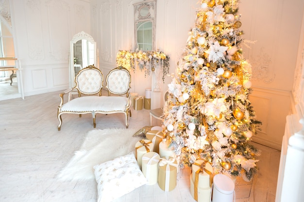 Sala de estar interna luxuosa e cara em estilo real, decorada com uma árvore de natal e grandes janelas