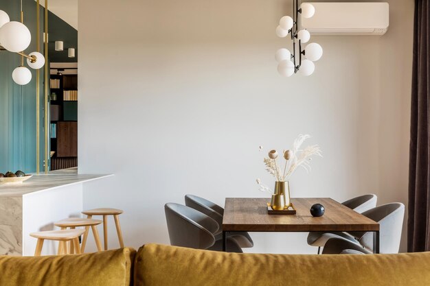 Sala de jantar moderna e vintage com mesa de madeira marrom, cadeiras cinza e lustre elegante Parede branca minimalista Acessórios criativos