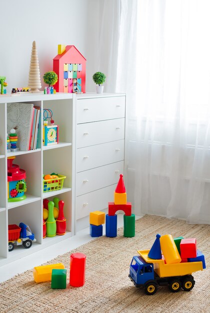 Foto sala de jogos infantis com brinquedos de blocos educacionais coloridos de plástico. andar de jogos para o jardim de infância de pré-escolares. quarto interior das crianças. espaço livre. mock up de fundo