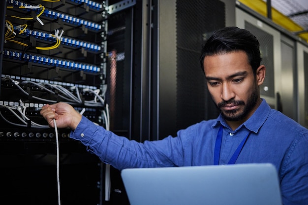 Sala de servidor de laptop de engenheiro e conexão de cabo para atualização de software ou manutenção à noite Codificador de segurança cibernética computação em nuvem e homem programador com computador para rede no data center