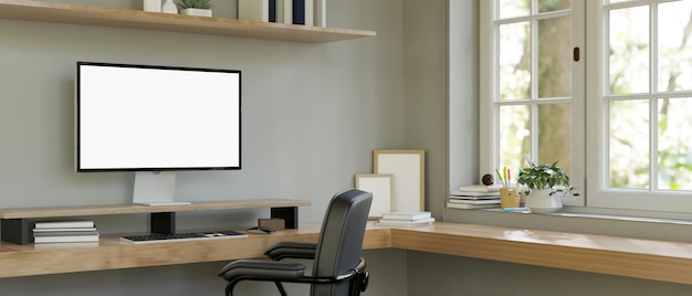 Sala de trabalho em casa mínima e confortável com mesa de canto do computador contra a janela