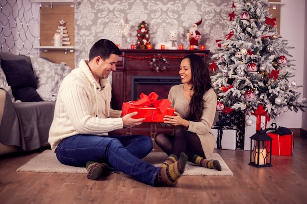 Sala decorada para festa de natal com lindo casal. Presente de Natal.