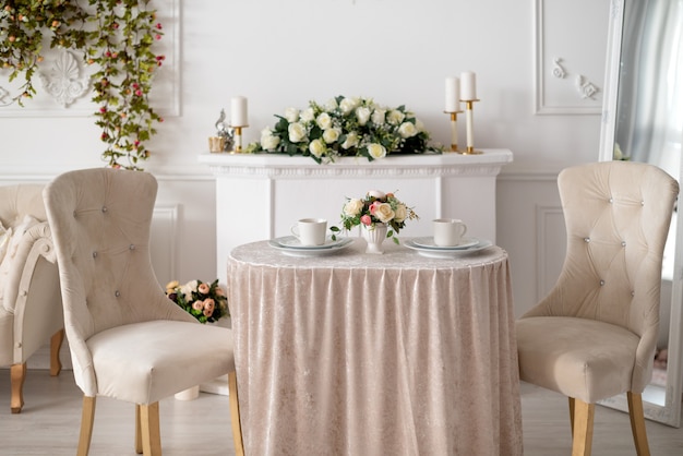 Sala de estar decorada en estilo clásico con sillas antiguas y mesa de café servida