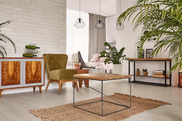 Una sala de estar con una mesa de madera y una silla verde.