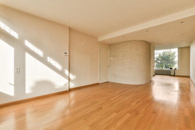 Una sala de estar con pisos de madera y una pared de ladrillo