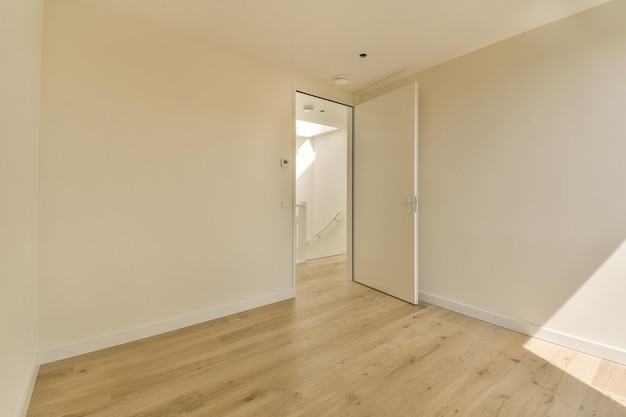 una sala de estar con pisos de madera y una puerta blanca