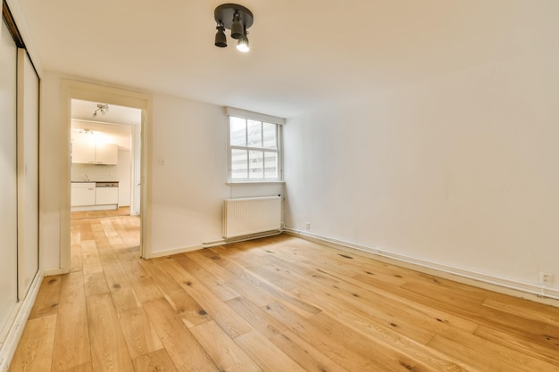 Foto una sala de estar con pisos de madera y una ventana.