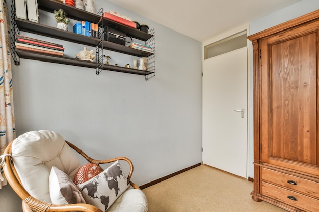 Una sala de estar con una silla y un estante de pared.