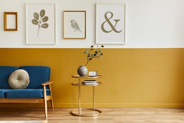 Sala de estar única en el interior de estilo moderno con sofá de diseño, elegante mesa de café dorada, marcos, flores en florero