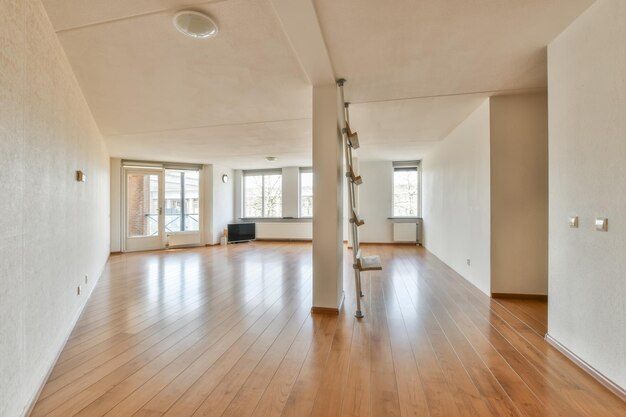 una sala de estar vacía con pisos de madera y paredes blancas en la habitación está muy limpia pero no hay muebles