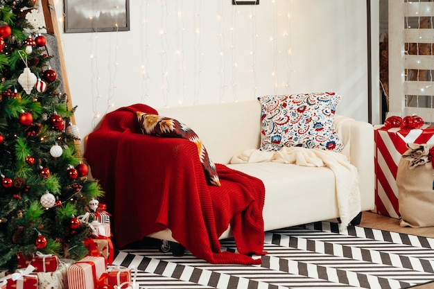 Sala de Navidad bellamente decorada con abeto y sofá blanco