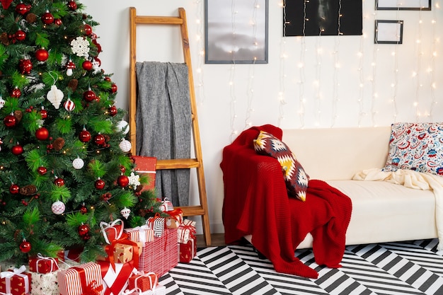 Sala de Navidad bellamente decorada con abeto y sofá blanco