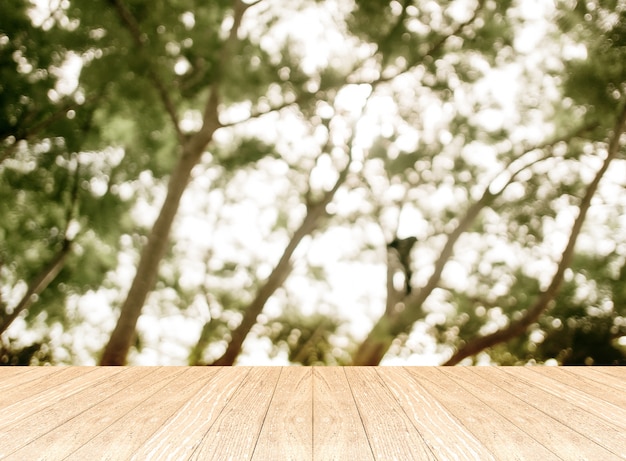 Sala de perspectiva vacía con bosque de árbol verde borrosa y piso de tablón de madera, simulacros de plantilla para la exhibición de su producto