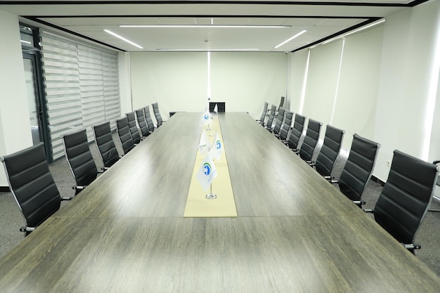 Sala de reuniones en una sala de conferencias moderna con sillas negras y tablero blanco