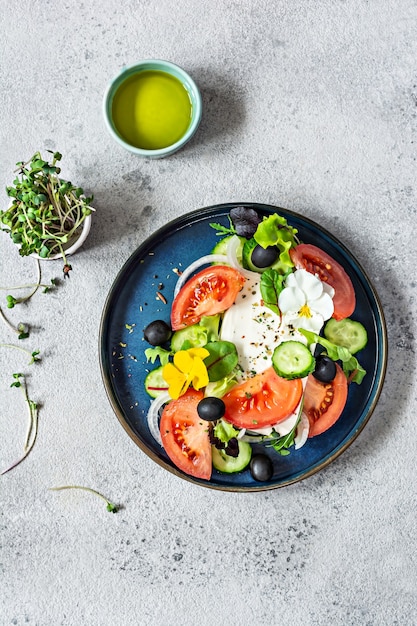 Salada apetitosa com queijo feta vegetais frescos tomates pepinos cebolas alface crocante microgreens e flores violetas Porção não padronizada de salada grega Comida com flores