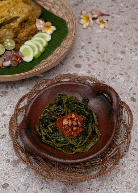 Salada balinesa tradicional servida com sambals de tomate chamado plecing kangkung. foco seletivo