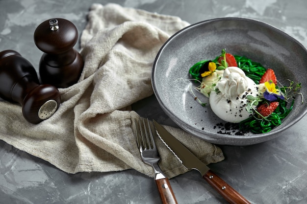 Salada Burrata com morangos e algas, em um cinza